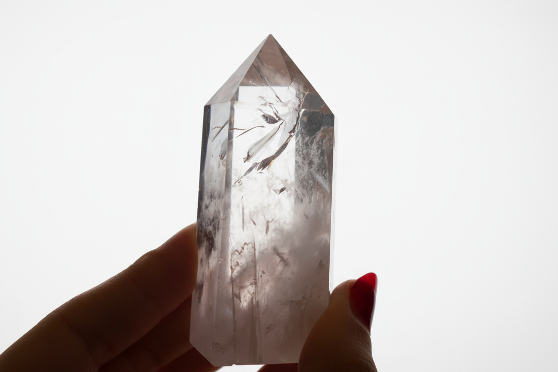 Crystal held by a hand against a white background