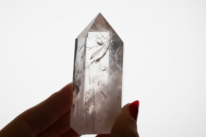 Crystal held by a hand against a white background
