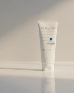 Tube of HaraMoon skincare product on a reflective surface with a neutral background