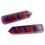 Two crystal points with purple and red stripes on a white background