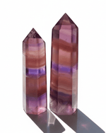 Two multicolored crystal points on a white background