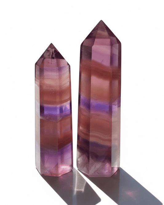 Two multicolored crystal points on a white background